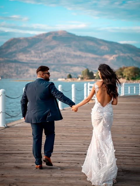 Wedding couple on pier with lake and mountain backdrop, Kelowna BC