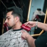 Barber giving a fade haircut during a commercial video shoot in Kelowna